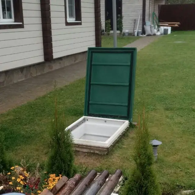 Zelené vstupné dvere pivnice osadené vedľa domu